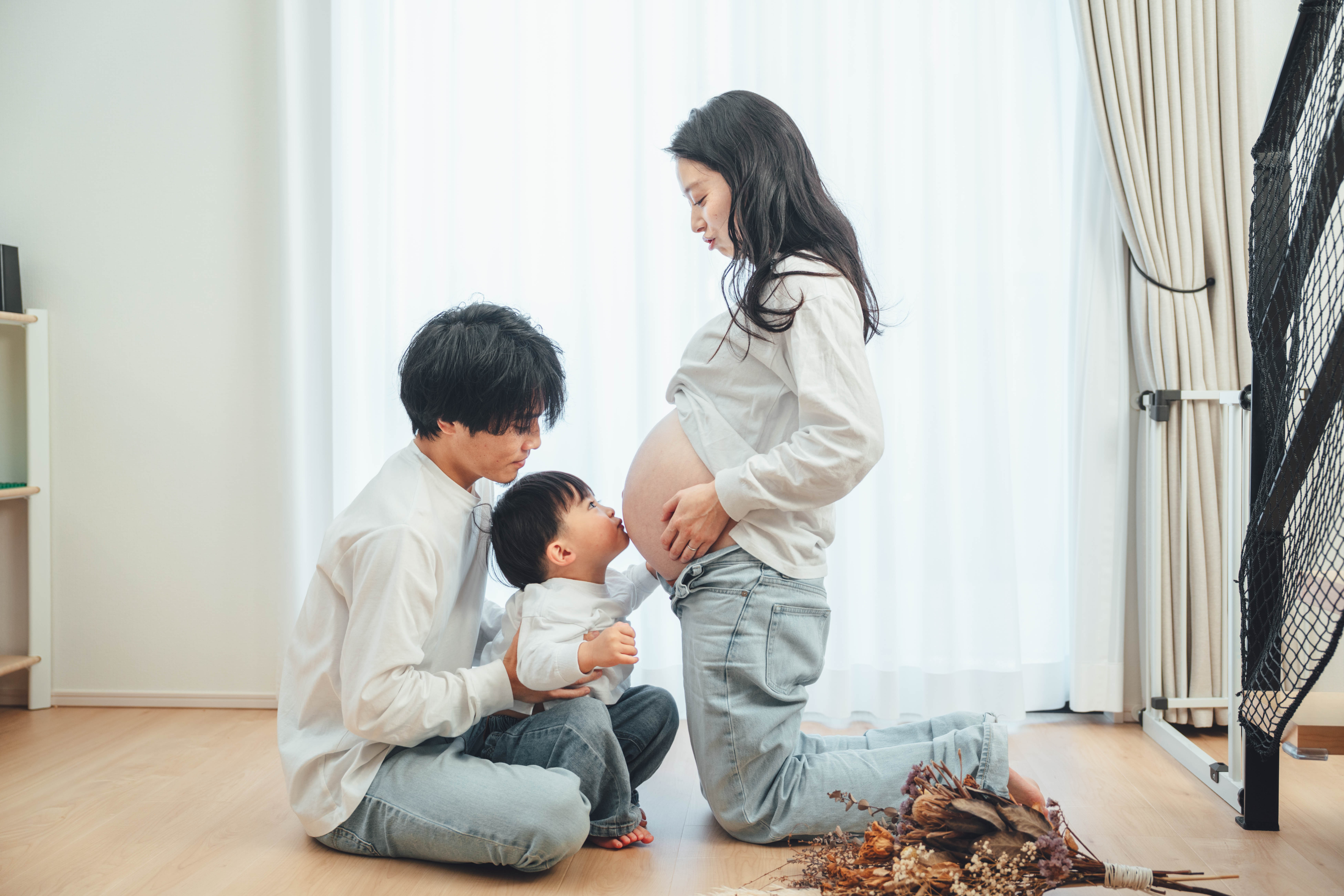 ファミリーマタニティ・上の子がお腹にキスする家族3人